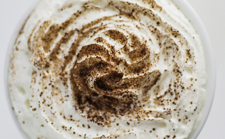 Looking down on a pile of whipped cream with cinnamon sprinkled on top 